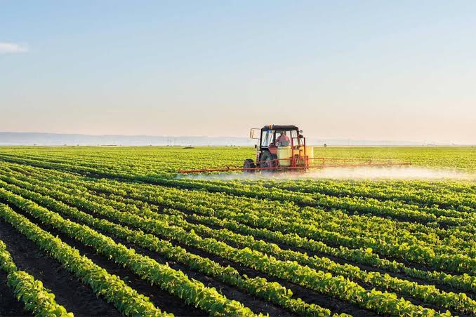 Crop sprayer applying treatment across green fields