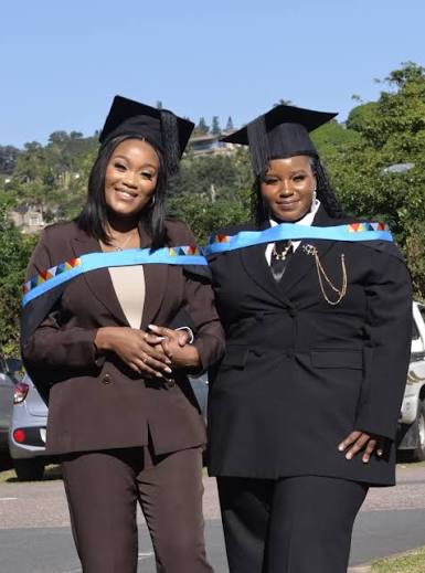 Two graduates posing outdoors